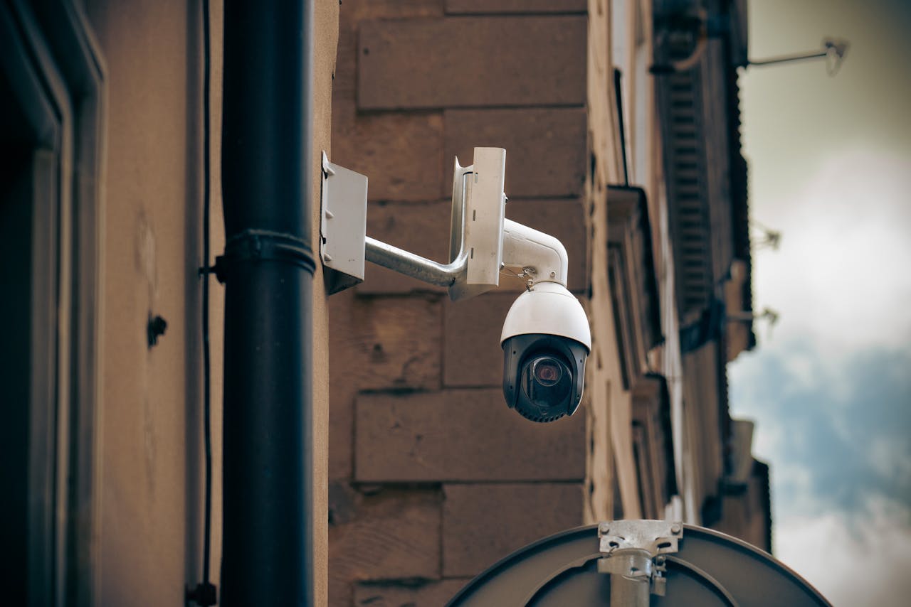About CCTV camera mounted on a building wall in an urban street setting, enhancing security.